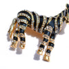 Zealous Zebra Brooch - A medium sized brooch shaped like a zebra standing still and looking forward, with a gold and black enamel background and studded with small crystals.