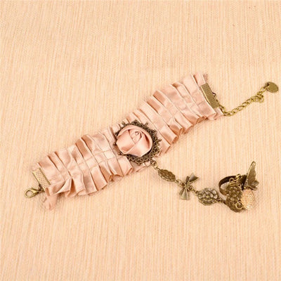 The Louisa Cuff - A lovely salmon-coloured cuff bracelet adorned with ribbons, metal hardware, and faux gems.