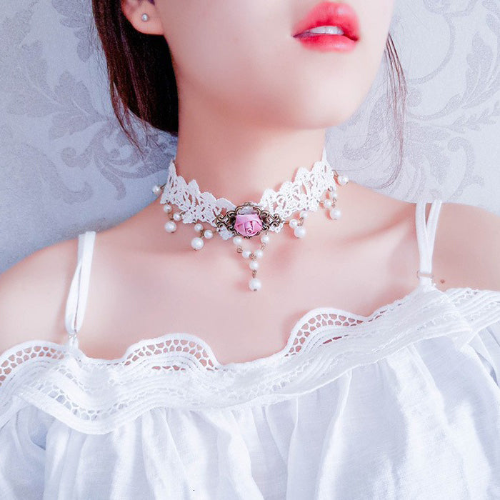 The Samantha Choker - A delicate white lace choker adorned with pink roses, faux pearls, and bronze hardware. 