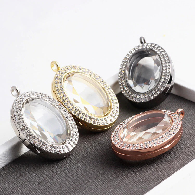 Ourania Magnetic Floating Locket - An oval shaped locket encrusted with small crystals.  This is a photo locket, so it has glass panels front and back that ensure anything in the locket can be seen from both sides. Available in gold, gunmetal (dark silver), rose gold, or silver coloured. Comes with a matching chain. 