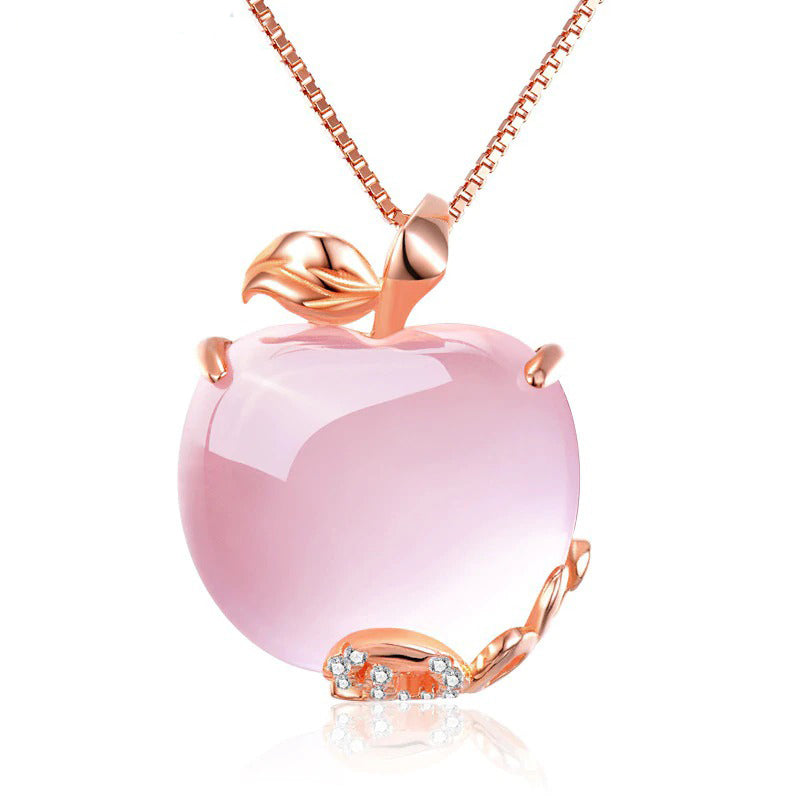 The Pomona Necklace - A lovely, luxurious-looking pink opal pendant shaped like an apple, with rose gold accents and a scattering of tiny quartz crystals. 