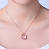 The Pomona Necklace - A lovely, luxurious-looking pink opal pendant shaped like an apple, with rose gold accents and a scattering of tiny quartz crystals.